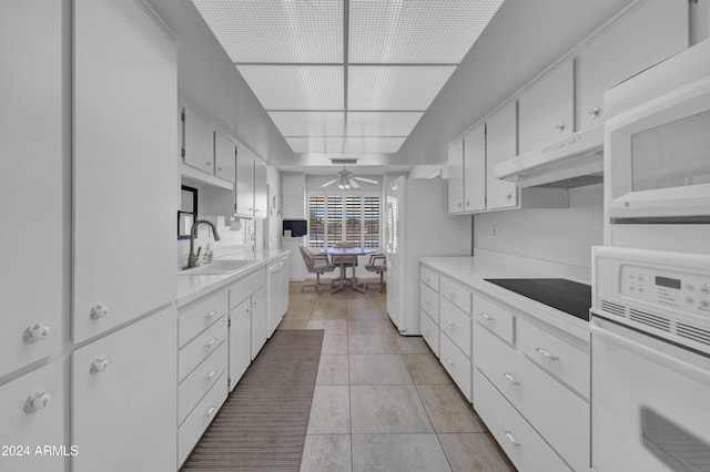 kitchen featuring white cabinets, light tile patterned flooring, white appliances, and sink