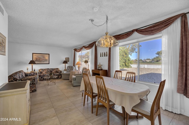 dining room with light tile patterned floors, a textured ceiling, and an inviting chandelier