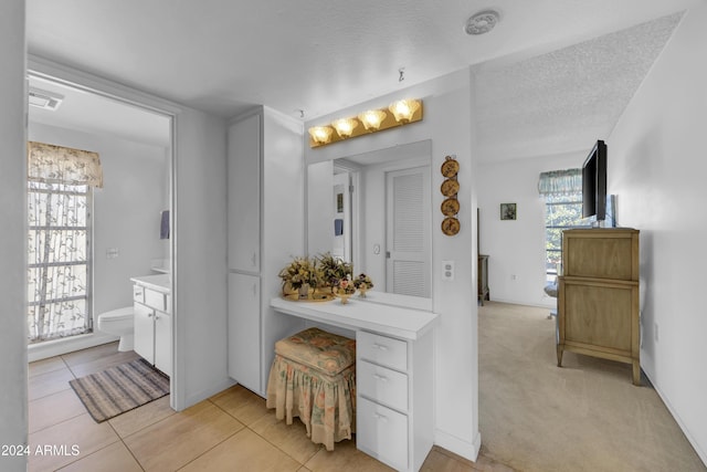 bathroom featuring tile patterned flooring, vanity, a textured ceiling, and toilet