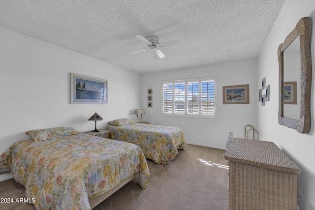 bedroom featuring ceiling fan, carpet floors, and a textured ceiling