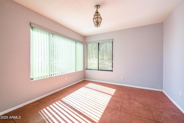 unfurnished room featuring tile patterned floors and baseboards