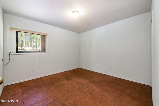 unfurnished room featuring baseboards