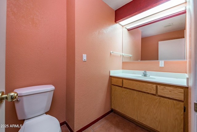 bathroom featuring visible vents, toilet, tile patterned flooring, baseboards, and vanity