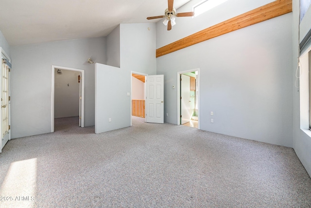 unfurnished bedroom featuring carpet flooring, connected bathroom, high vaulted ceiling, and ceiling fan