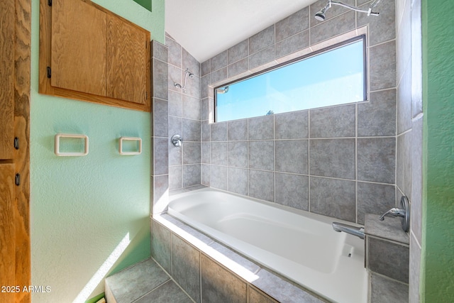 full bath featuring tiled shower / bath combo and a textured wall