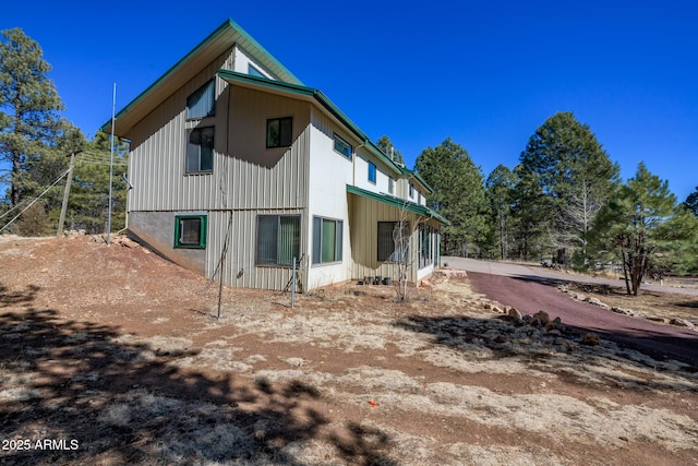 back of house with dirt driveway