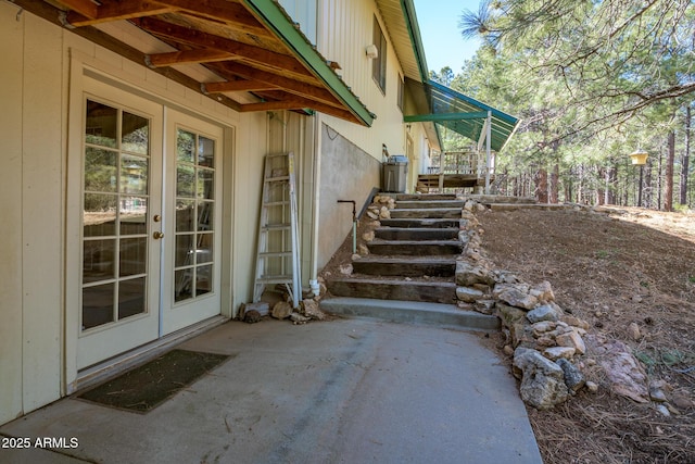 view of property exterior featuring a patio area, french doors, and stairs