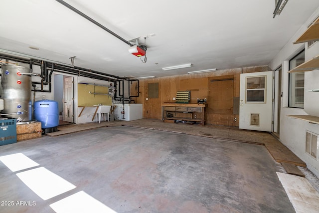 garage featuring water heater, a garage door opener, and a sink