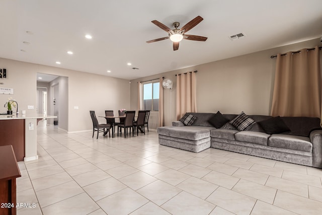 tiled living room with ceiling fan and sink