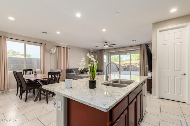 kitchen featuring ceiling fan, a healthy amount of sunlight, sink, and a kitchen island with sink