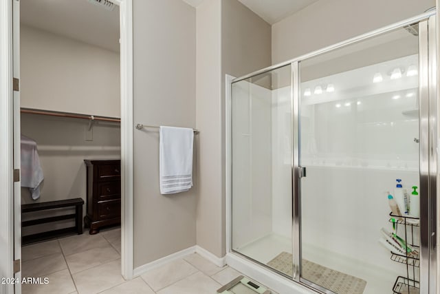 bathroom featuring a shower with door and tile patterned floors