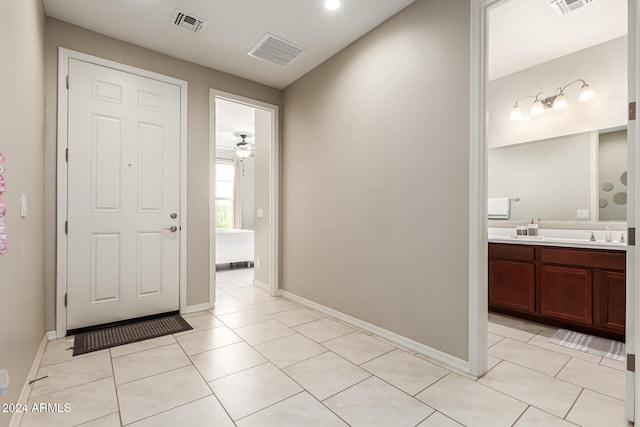 tiled entryway featuring sink and ceiling fan