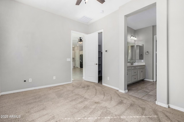 unfurnished bedroom featuring stainless steel refrigerator, ensuite bath, sink, and light carpet