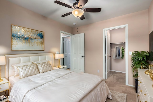 carpeted bedroom featuring a spacious closet, a closet, and ceiling fan