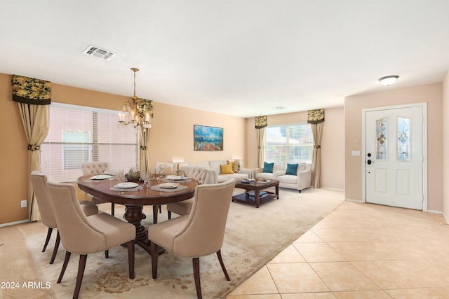 dining space featuring light tile patterned flooring and an inviting chandelier