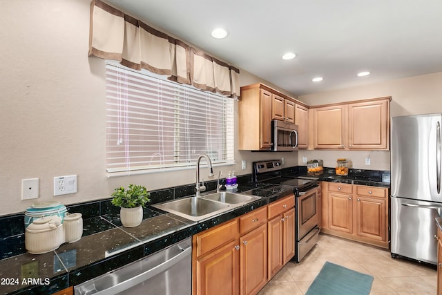 kitchen with appliances with stainless steel finishes, sink, and light tile patterned floors