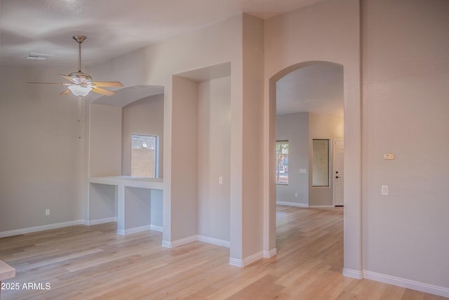 15067 W Taylor St, Goodyear, AZ 85338 - unfurnished room featuring arched walkways, light wood-style flooring, a ceiling fan, and baseboards