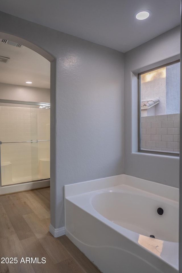 15067 W Taylor St, Goodyear, AZ 85338 - bathroom featuring wood finished floors, a garden tub, and baseboards