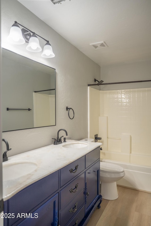 15067 W Taylor St, Goodyear, AZ 85338 - bathroom featuring wood finished floors, double vanity, bathtub / shower combination, and toilet