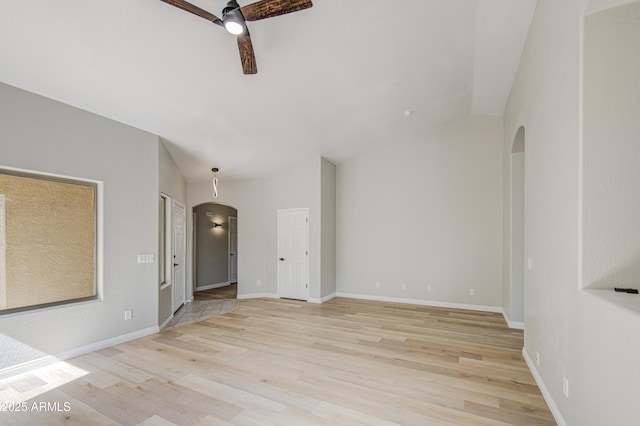 15067 W Taylor St, Goodyear, AZ 85338 - empty room featuring arched walkways, ceiling fan, light wood-style floors, and baseboards