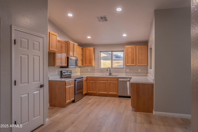 15067 W Taylor St, Goodyear, AZ 85338 - kitchen with appliances with stainless steel finishes, a sink, light wood-style floors, light countertops, and recessed lighting