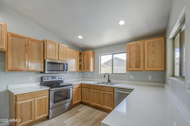 15067 W Taylor St, Goodyear, AZ 85338 - kitchen with appliances with stainless steel finishes, a sink, lofted ceiling, light wood-type flooring, and light stone counters