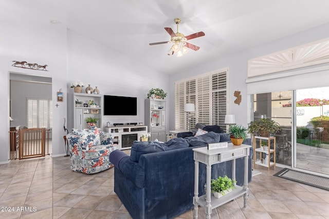 living room with plenty of natural light, ceiling fan, a multi sided fireplace, and lofted ceiling