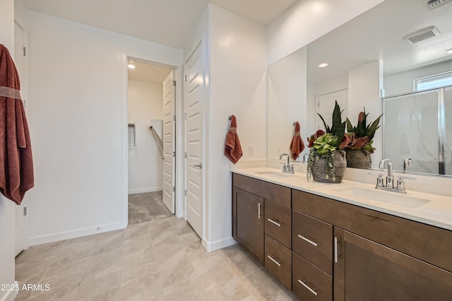 bathroom with double vanity, a stall shower, visible vents, and a sink