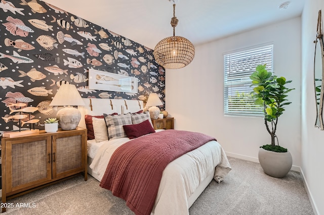 bedroom featuring baseboards, carpet, an accent wall, and wallpapered walls