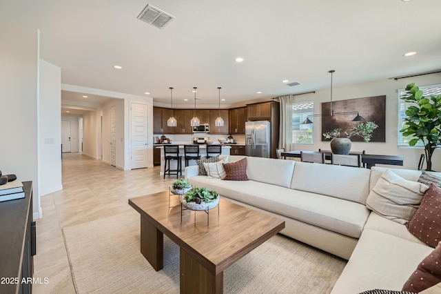 living area with visible vents, recessed lighting, and baseboards