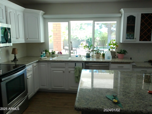 6139 E Voltaire Ave, Scottsdale, AZ 85254 - kitchen featuring appliances with stainless steel finishes, white cabinets, tasteful backsplash, wood finished floors, and glass insert cabinets