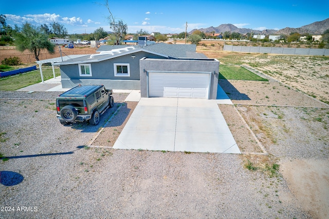 view of front of home featuring a mountain view, a garage, and a front lawn