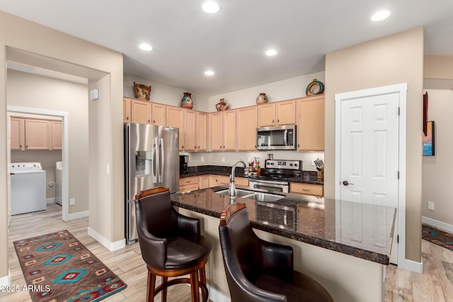 17139 S 174th Dr, Goodyear, AZ 85338 - kitchen with light brown cabinets, a sink, light wood-type flooring, appliances with stainless steel finishes, and washer / dryer