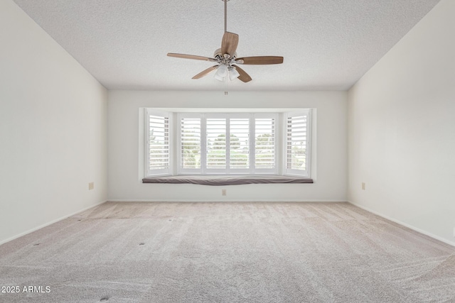 carpeted spare room featuring a textured ceiling and ceiling fan