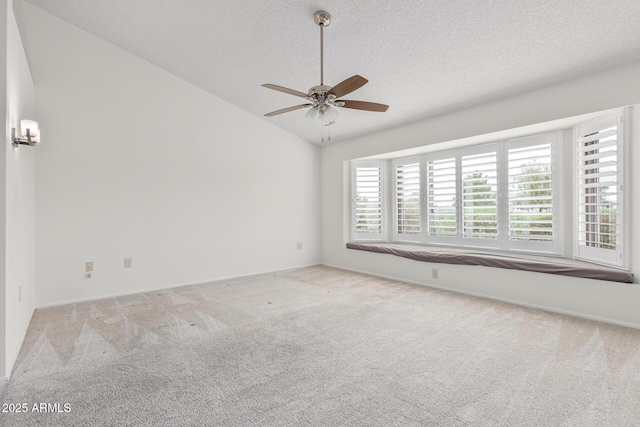 carpeted spare room featuring ceiling fan, lofted ceiling, and a textured ceiling