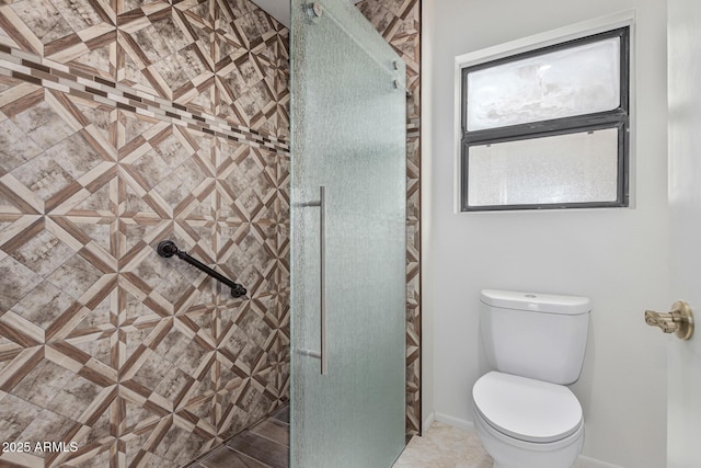 bathroom featuring tiled shower and toilet