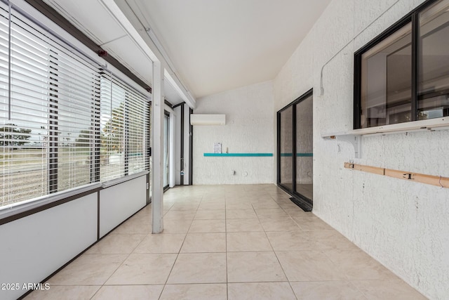 hall featuring light tile patterned floors, a wall unit AC, and a textured wall