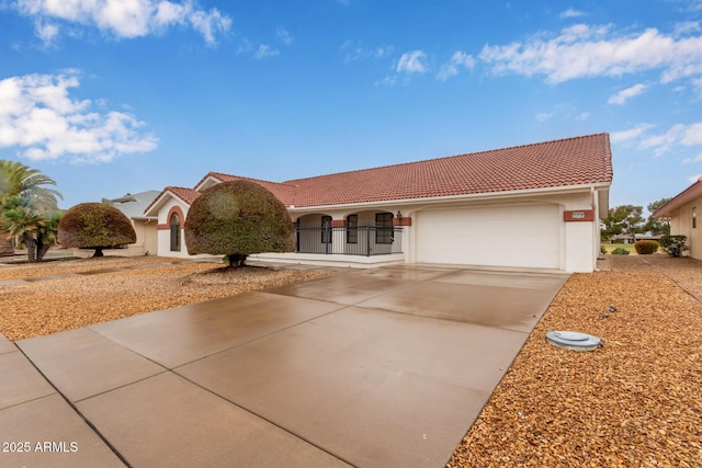 view of front of house featuring stucco siding, a gate, concrete driveway, a garage, and a tiled roof