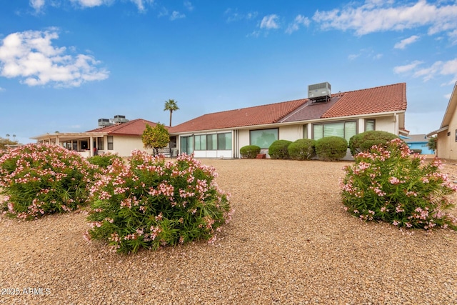 back of property featuring a tile roof, cooling unit, and stucco siding