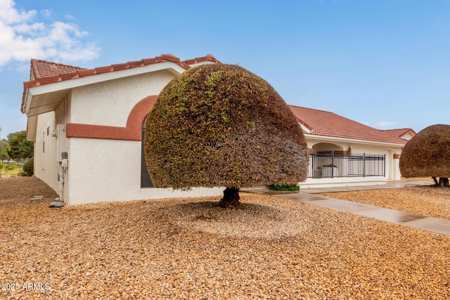 view of front of property featuring stucco siding, an attached garage, and a tiled roof