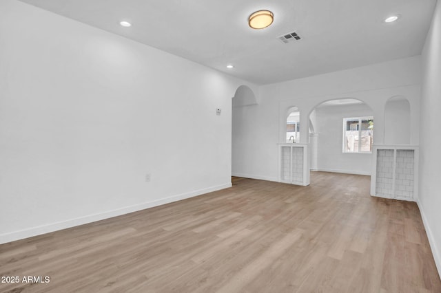 538 S Macdonald, Mesa, AZ 85210 - unfurnished living room with arched walkways, light wood-type flooring, and recessed lighting