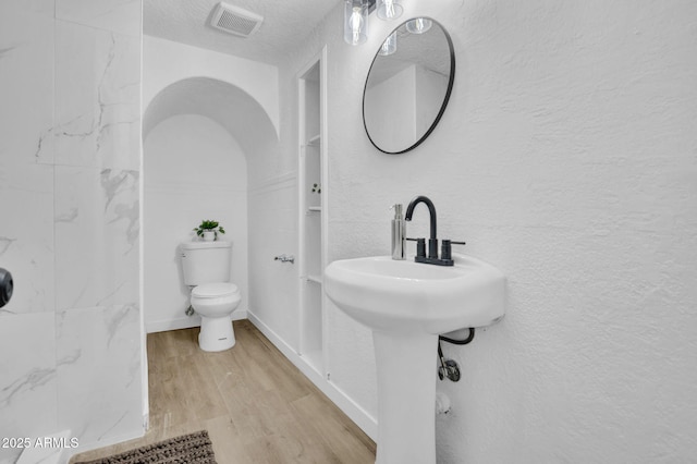 538 S Macdonald, Mesa, AZ 85210 - full bath featuring wood finished floors, a textured wall, a textured ceiling, and a shower