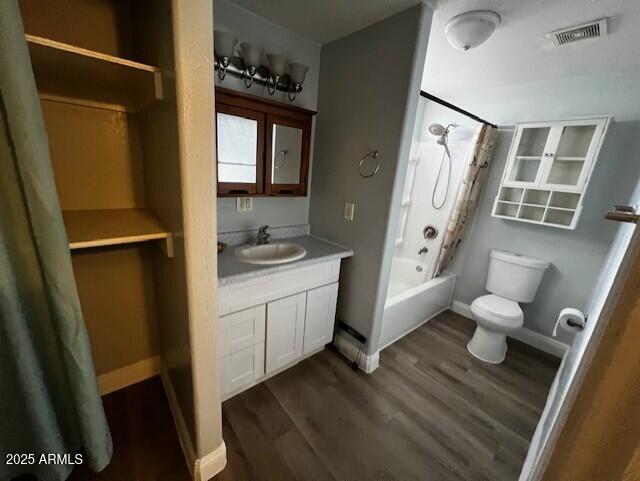 full bathroom featuring vanity, hardwood / wood-style floors, shower / bath combination with curtain, and toilet