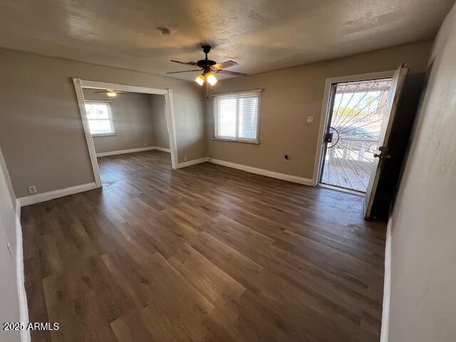 unfurnished room with ceiling fan, a healthy amount of sunlight, and dark hardwood / wood-style floors