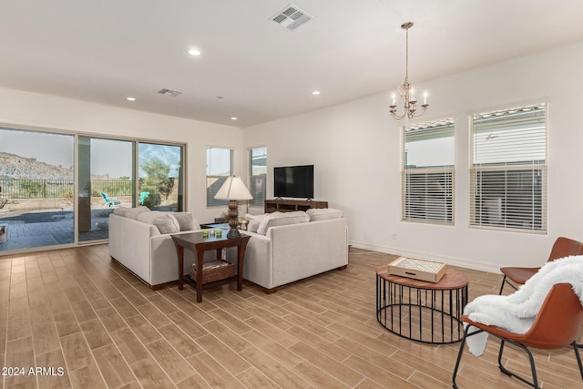 living room with a chandelier and light wood-type flooring