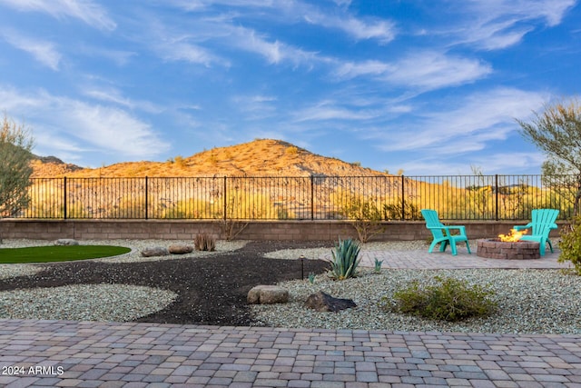 view of yard with an outdoor fire pit, a mountain view, and a patio area