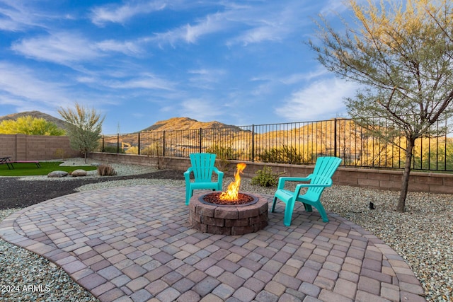 view of patio / terrace with a mountain view and an outdoor fire pit