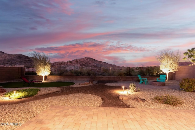 patio terrace at dusk featuring a mountain view and an outdoor fire pit