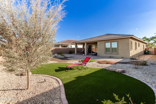 rear view of property featuring a patio and a lawn