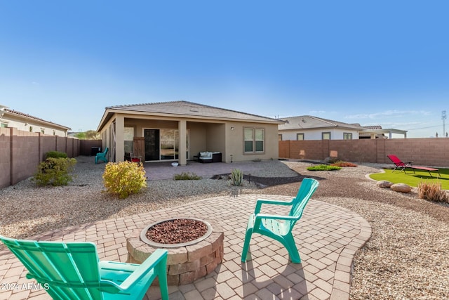 rear view of property featuring a patio and a fire pit